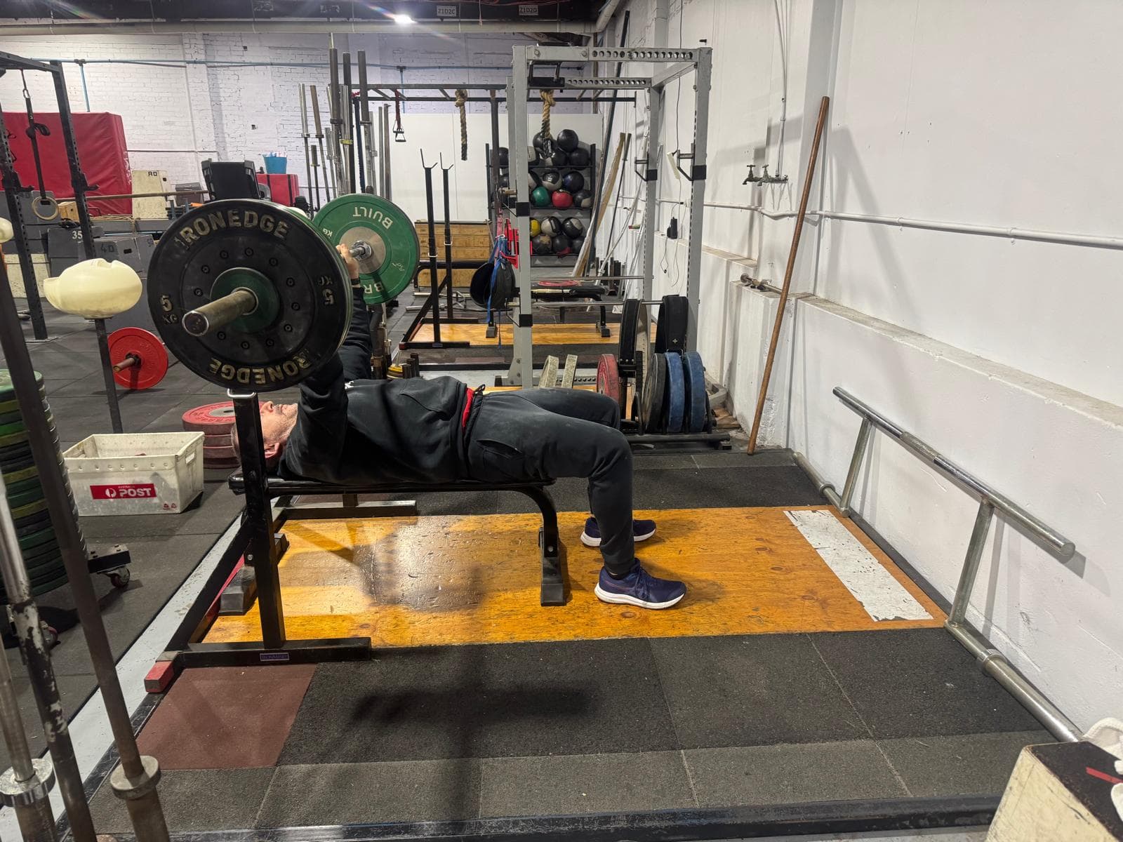 A member bench pressing a loaded barbell