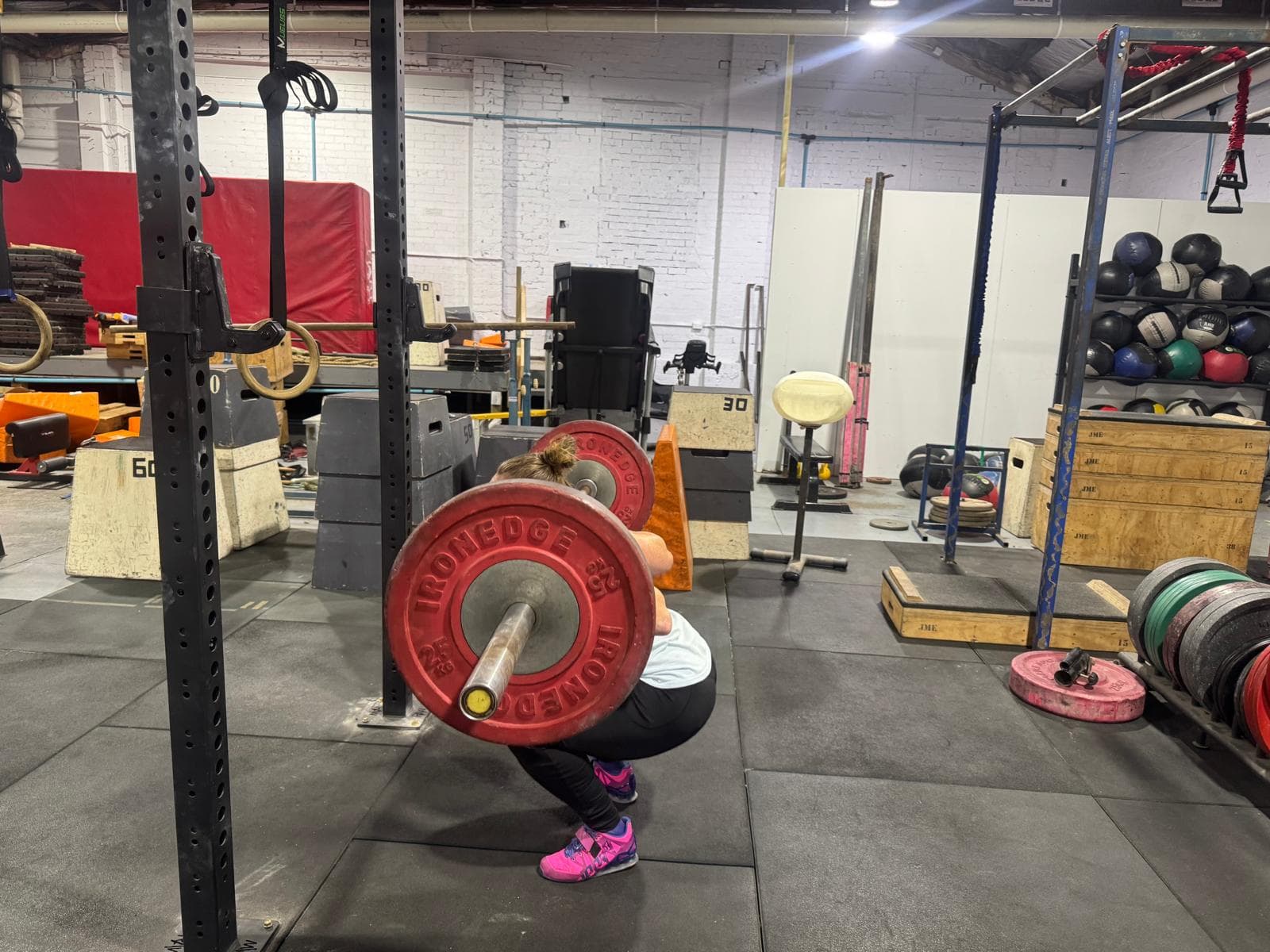 Two members front squatting together in the gym