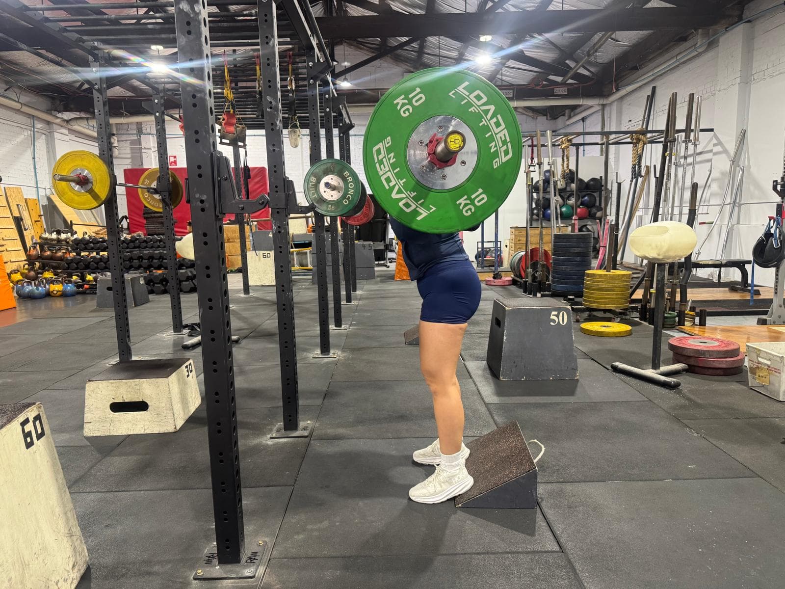 A member in a deep front squat with a loaded barbell