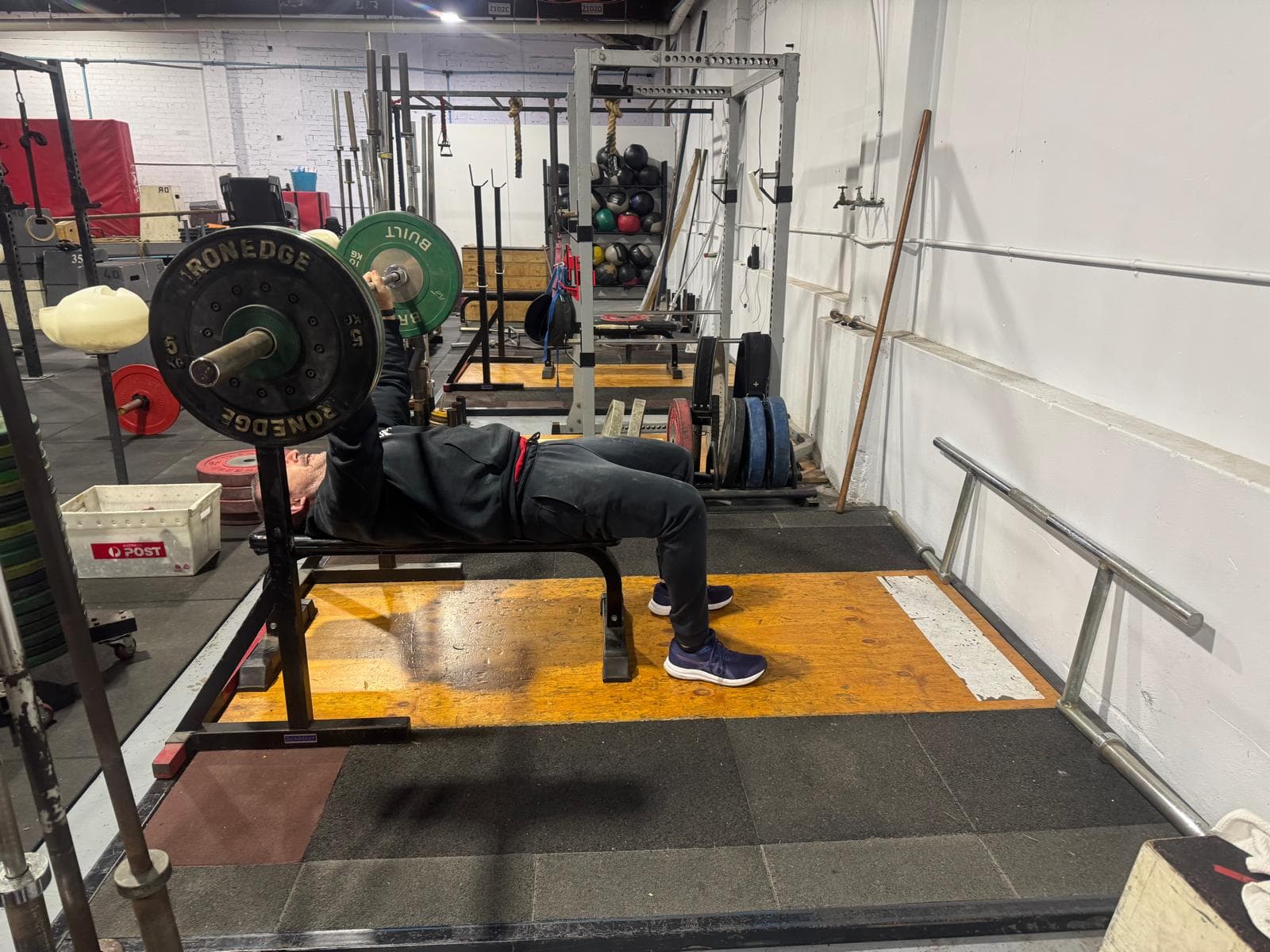 A member bench pressing a loaded barbell