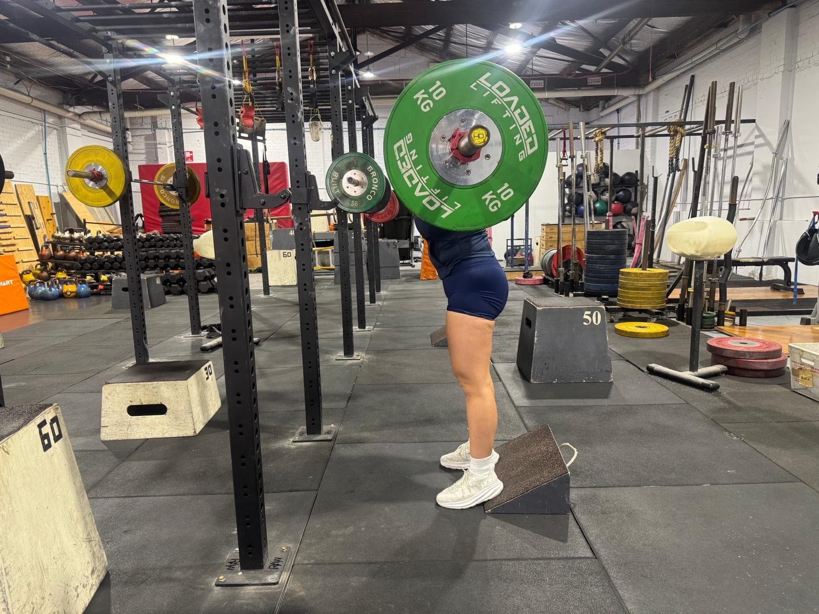 A member in a deep front squat with a loaded barbell